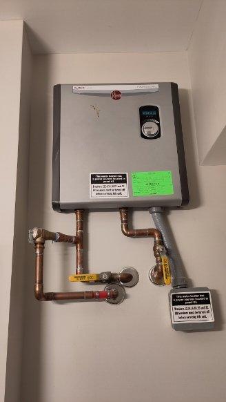 Performed assessment of two Rheem tankless water heaters requiring isolation valve installation. First unit located on first floor bathroom, second unit on second floor bathroom. Both units feature copper piping connections with existing valves. Documented current installation configuration with photographs to develop appropriate isolation valve solution as requested by customer.