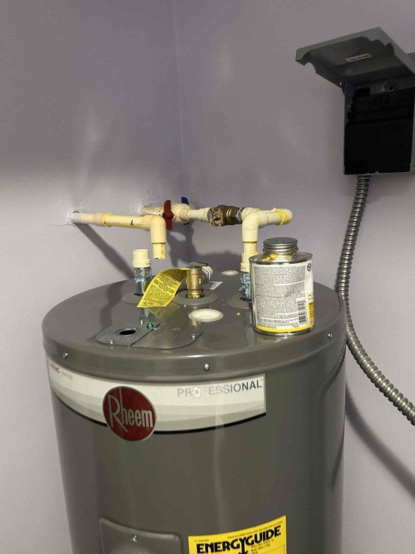 Conducted code compliance verification of two recently installed Rheem Professional water heaters in units #2011 and #304. Inspected all plumbing connections, PVC piping, electrical junction boxes, and verified proper hot/cold water line configuration. Both units were confirmed to meet all required code specifications for inspection approval.