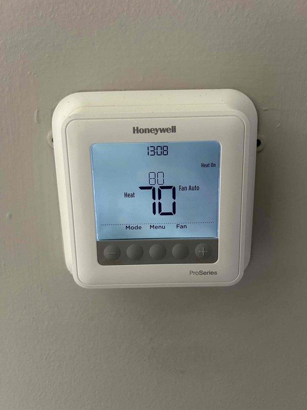 Performed diagnostic assessment on HVAC system in response to customer's concern about excessive runtime and increased energy consumption. Conducted refrigerant pressure testing using both analog gauges and digital measurement tools, revealing system was undercharged by approximately 4 pounds. Inspected thermostat operation (Honeywell ProSeries) which was functioning correctly in heating mode with appropriate temperature settings.