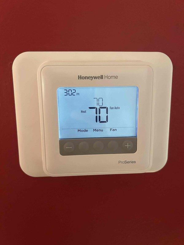 Conducted routine care plan tune-up on customer's heat pump/air handler system located in basement. Performed electrical diagnostic testing using Fieldpiece SC260 clamp meter, confirming proper amperage readings of 0.58. Verified thermostat functionality on Honeywell Home ProSeries which was operating correctly with heat set to 70°F and fan in auto mode.