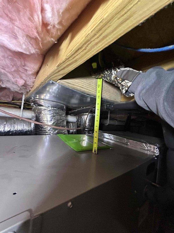 Inspected guest house #2 heating system in attic crawl space. Found improperly sized ductwork with inadequate clearances (measured 7-8 inches) between components. System efficiency compromised by existing insulation configuration. Identified and documented issues with metallic insulation on supply pipes that are contributing to the heating deficiency.
