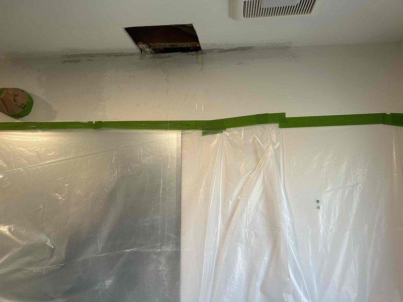 Responded to customer complaint of ceiling water leak in bathroom. Performed diagnostic inspection, which revealed the issue originated from the plumbing stack vent pipe on roof. Created access point in ceiling to examine affected area and installed protective plastic sheeting to contain work area. Inspected roof vent pipe installation and flashing for proper sealing to prevent further water intrusion.