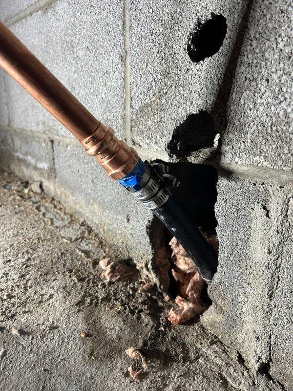 Replaced leaking section of copper water supply line through concrete block wall. Installed new copper piping with proper fittings and shut-off valve. Completed penetration through wall and floor to ensure proper installation and eliminate leak.
