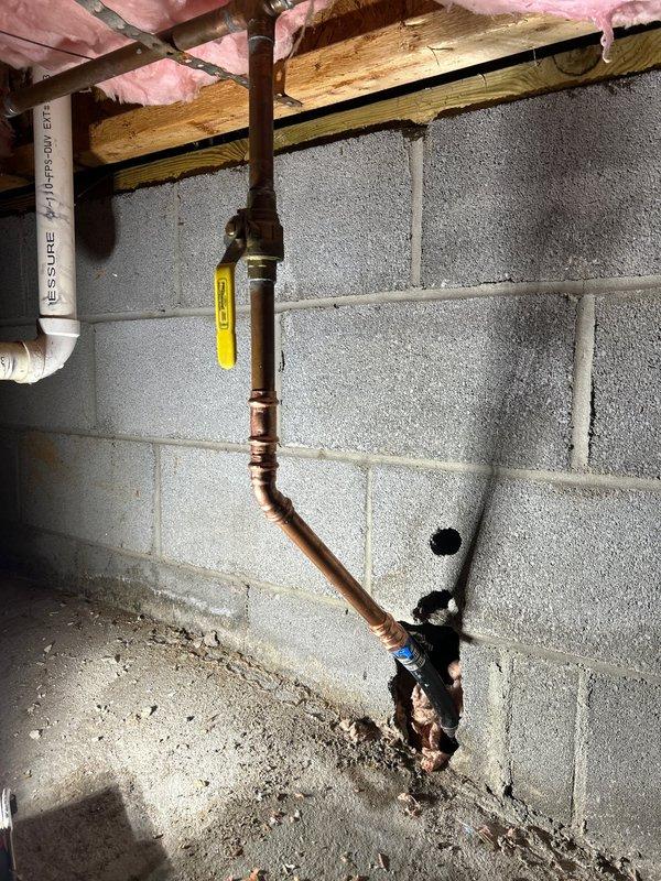 Replaced leaking section of copper water supply line through concrete block wall. Installed new copper piping with proper fittings and shut-off valve. Completed penetration through wall and floor to ensure proper installation and eliminate leak.