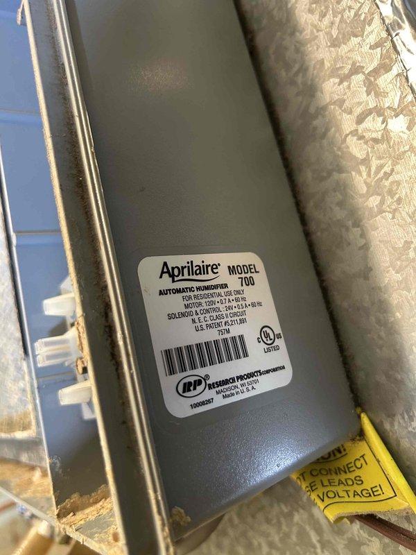 Responded to water leak service call for an HVAC system with an Aprilaire Model 700 automatic humidifier. Upon inspection, discovered significant dust accumulation on the evaporator coil and identified an improperly installed access panel in the ceiling that was contributing to the leak. Cleaned affected components and properly secured the access panel to resolve the water leakage issue.