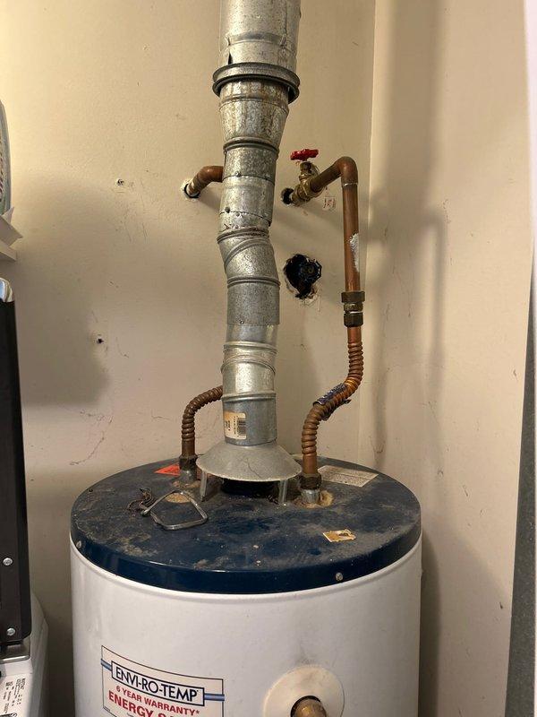 Inspected existing 40-gallon gas water heater (Enviro-Temp brand) located on main floor next to laundry above crawlspace. Provided comprehensive estimate for both tank and tankless replacement options, noting current installation includes standard copper supply lines, gas connection, and galvanized metal flue venting system.