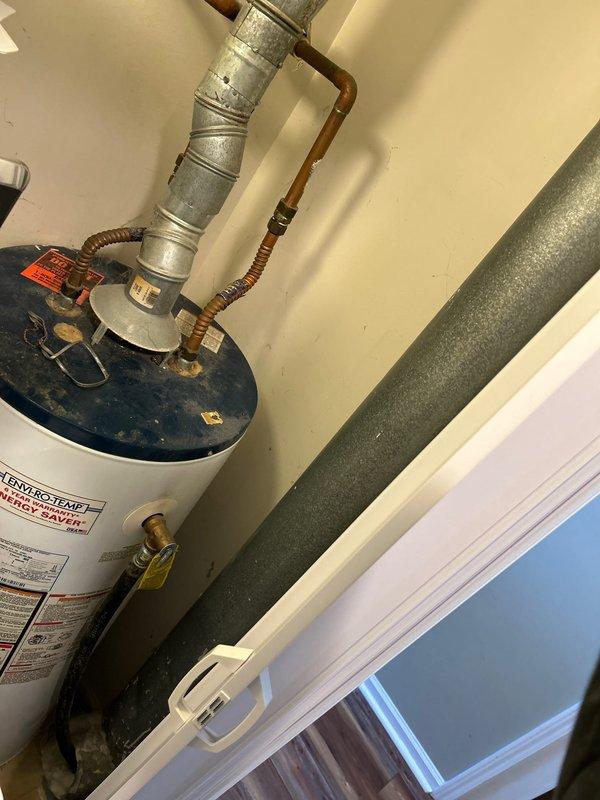 Inspected existing 40-gallon gas water heater (Enviro-Temp brand) located on main floor next to laundry above crawlspace. Provided comprehensive estimate for both tank and tankless replacement options, noting current installation includes standard copper supply lines, gas connection, and galvanized metal flue venting system.
