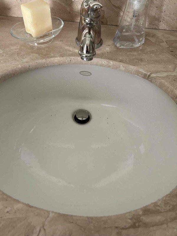 Performed comprehensive inspection of residence plumbing systems. Diagnosed issues with bathroom sink showing signs of sediment and poor drainage. Evaluated water heater system and connected filtration units, noting current condition and operational status. Documented multiple repair needs including master bathroom shower pressure issues, aerator replacement requirements, loose toilet in upstairs hall bath, and faulty shut-off valve/supply line for future service.