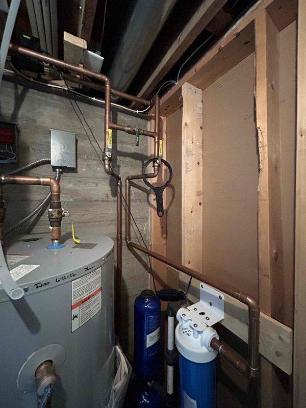 Performed comprehensive inspection of residence plumbing systems. Diagnosed issues with bathroom sink showing signs of sediment and poor drainage. Evaluated water heater system and connected filtration units, noting current condition and operational status. Documented multiple repair needs including master bathroom shower pressure issues, aerator replacement requirements, loose toilet in upstairs hall bath, and faulty shut-off valve/supply line for future service.