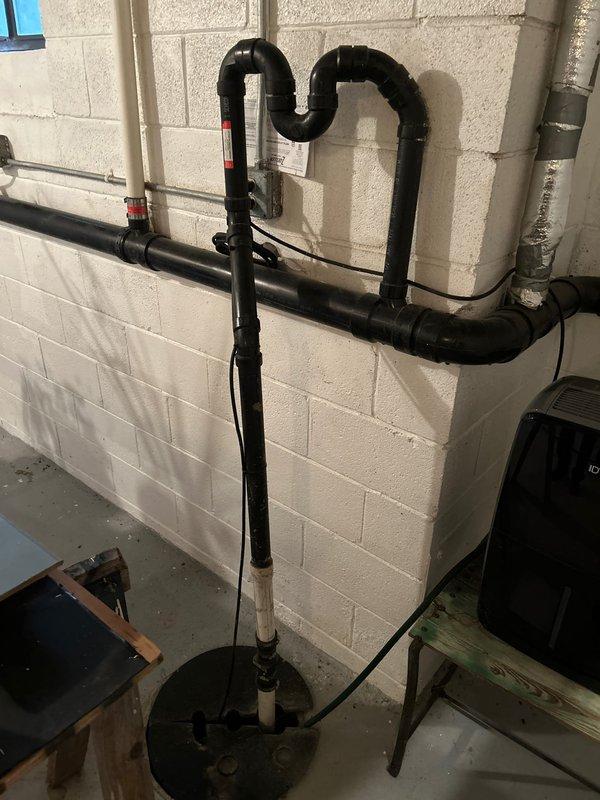 Conducted site inspection to provide estimate for sump pump relocation. Assessment included examining current drainage system with black PVC pipes, P-traps, and connection points in basement area. Exterior evaluation of discharge location was performed to determine optimal positioning for relocated pump system. Quote prepared and will be forwarded to homeowner and Logan Coslow.