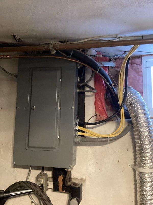 Conducted comprehensive assessment of existing electrical panel for generator installation compatibility. Documented panel condition, noting visible wall damage around mounting area and inspecting all connected conduits and wiring. Evaluated available connection points and load capacity to determine appropriate generator integration requirements.