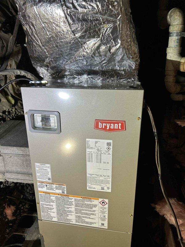 Completed installation of a 2-ton 15 SEER Bryant Sentry Series heat pump system (model GH5SAN52400A) with multi-speed air handler (model FJ5SANXB24L00), 10KW heat kit, and digital programmable thermostat. Installation included all necessary components: outdoor unit pad with snow legs, electrical connections, refrigerant line components, condensation pump, SS2 coil drain safety water sensor, overflow protection, and transition to existing ductwork.
