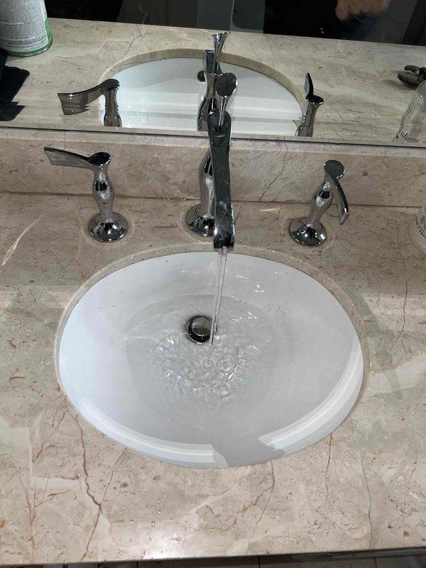 Successfully replaced damaged plumbing section by cutting into wall to access the problematic tee, removed affected pipe, and installed new PVC components. Post-installation testing confirmed proper water flow through the sink drain system with no leaks observed in the new P-trap assembly and supply line connections.