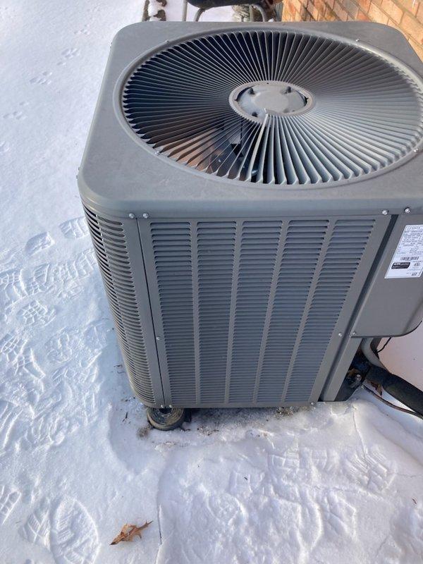 Responded to service call for a 2-year-old heat pump system with no heat. Upon inspection, found the outdoor unit had shifted 4-6 inches off its pad with significant physical damage. Visual assessment confirmed condenser fan assembly damage. System was non-operational due to displacement likely caused by external forces, with snow accumulation around the unit complicating the situation.