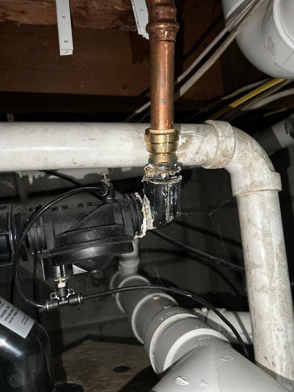 Inspected customer's sump pump system due to reported pipe vibrations in basement. Identified deteriorating connection point between copper and PVC pipes with failing sealant and signs of previous repair attempts. Observed significant corrosion at metal pipe junctions where older metal pipes connect to newer PVC components, replaced damaged seals and secured loose pipe connections to eliminate vibration issues.