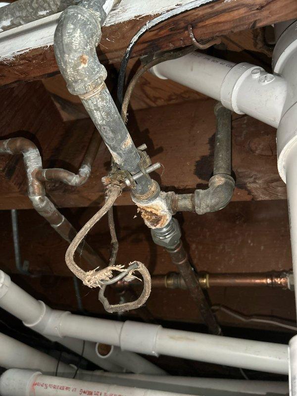 Inspected customer's sump pump system due to reported pipe vibrations in basement. Identified deteriorating connection point between copper and PVC pipes with failing sealant and signs of previous repair attempts. Observed significant corrosion at metal pipe junctions where older metal pipes connect to newer PVC components, replaced damaged seals and secured loose pipe connections to eliminate vibration issues.