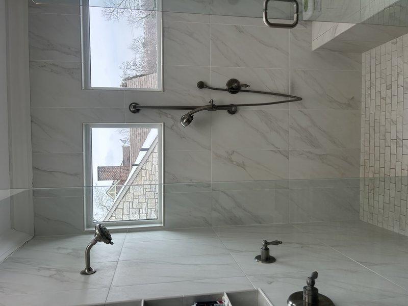 Responded to service request for leaking shower head. Upon inspection, removed and replaced worn valve stem assembly with new component, which included replacing deteriorated O-ring/washer that was causing the leak. Tested fixture after repair and confirmed proper operation with no leaks.