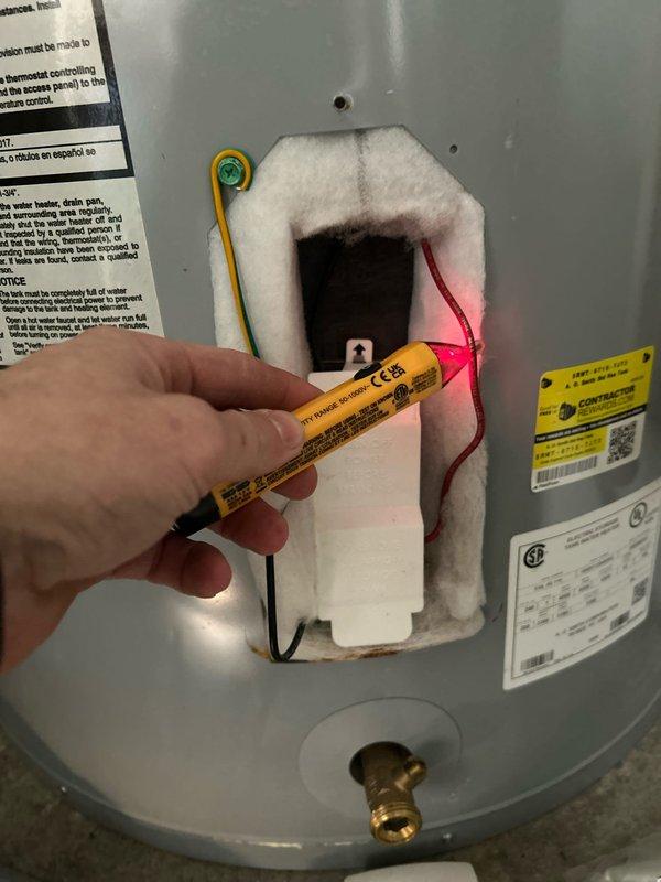 Diagnosed no hot water issue on 6-year-old tanked water heater by conducting electrical testing, which revealed damaged/burned thermostat connections. Visual inspection showed significant deterioration and discoloration of insulation surrounding the electrical components, indicating thermal damage to the control assembly.
