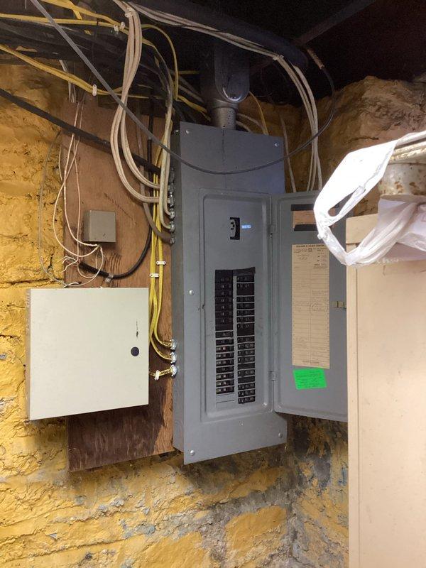 Conducted electrical estimate for potential Kohler generator installation. Inspected existing electrical panel system, which includes main circuit breaker panel and adjacent junction box mounted on masonry wall. Documented current panel configuration, wire routing, and available capacity to determine requirements for generator integration.