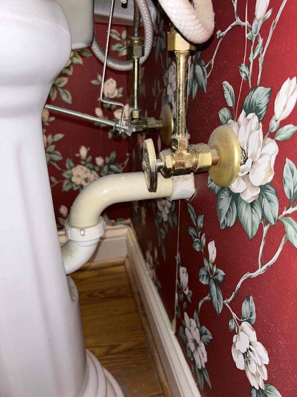 Conducted plumbing inspection per PSA request regarding detached shower knob. Examined bathroom fixtures including sink drainage functionality and water flow. Inspected brass shutoff valve and PVC drain pipe connections. Verified proper operation of sink drain system with no visible leaks in the plumbing components.