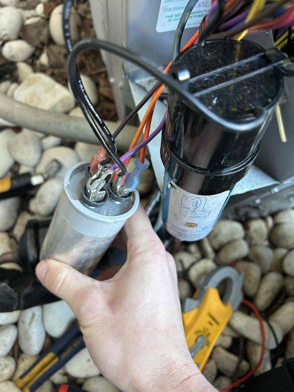 Responded to no heat call for 1-year-old heat pump system operating in electric mode. Diagnosed failed capacitor as evidenced by system running on emergency heat. Replaced capacitor, reconnected all wiring terminals (black, orange, purple) to proper connections, and verified proper operation of the unit. System is now heating normally.