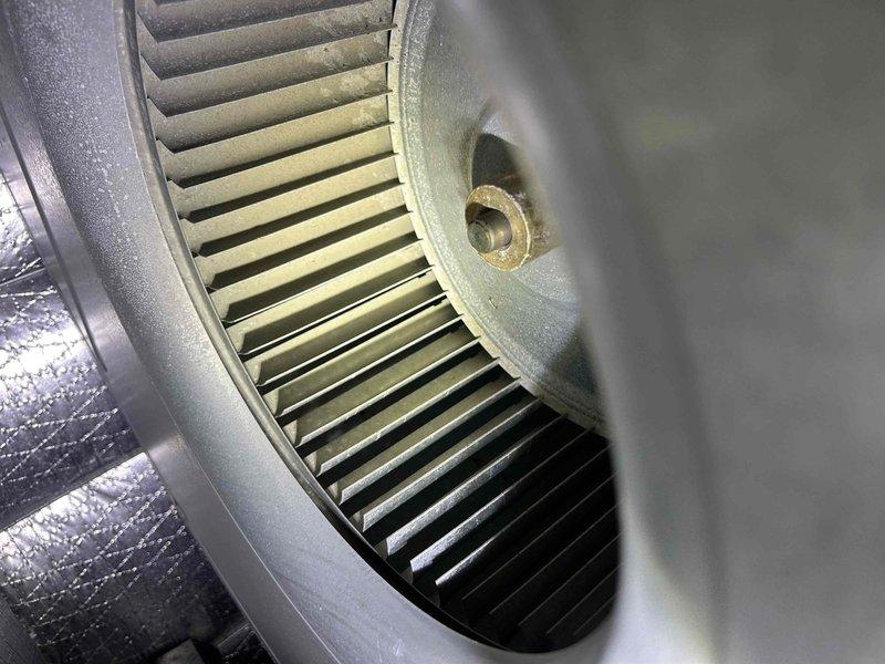 Completed second service ticket of a 10-year care plan for GEO system, working in conjunction with Trio technician at the same location. Inspected blower wheel assembly which showed normal dust accumulation. Examined electrical components including capacitor and associated wiring connections (blue, yellow, red, black, and pink) within the unit cabinet, verifying proper installation and function.