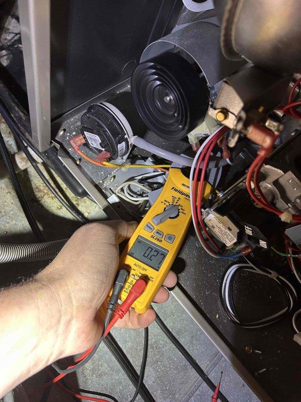Completed Club Green PSA tune-up on customer's AC and gas furnace as requested by Andrew. Performed visual inspection of outdoor condenser unit, which showed normal weathering but remains properly installed on concrete pad with intact electrical connections. Conducted electrical testing on furnace components with multimeter, recording amperage reading of 0.27 during diagnostic evaluation of blower motor assembly.