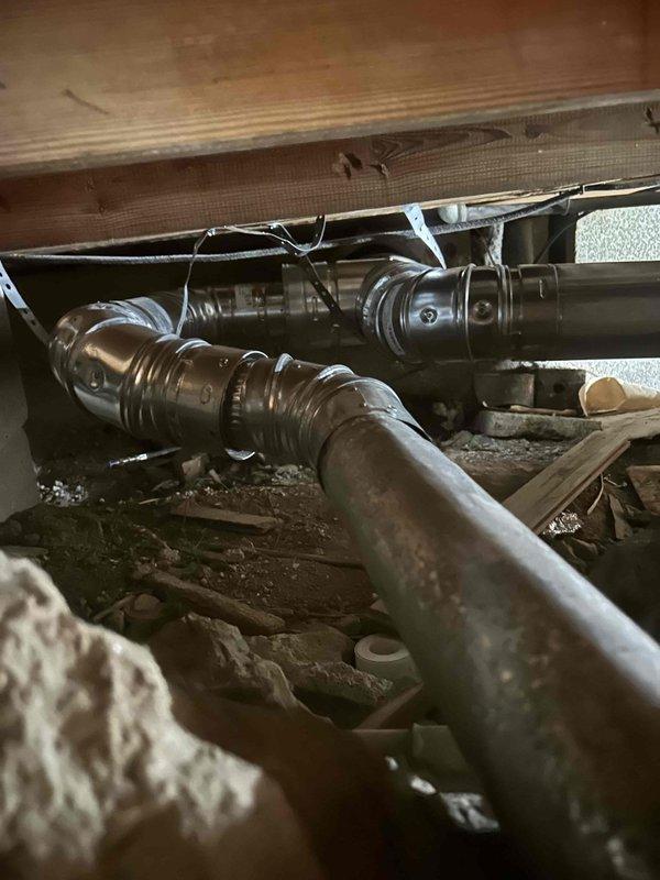 Successfully installed custom chimney liner for water heater and furnace vent in confined crawl space, requiring specialized technicians to navigate the restricted access area. Properly secured all ductwork connections with appropriate metal straps and bands to ensure code-compliant ventilation system operation.