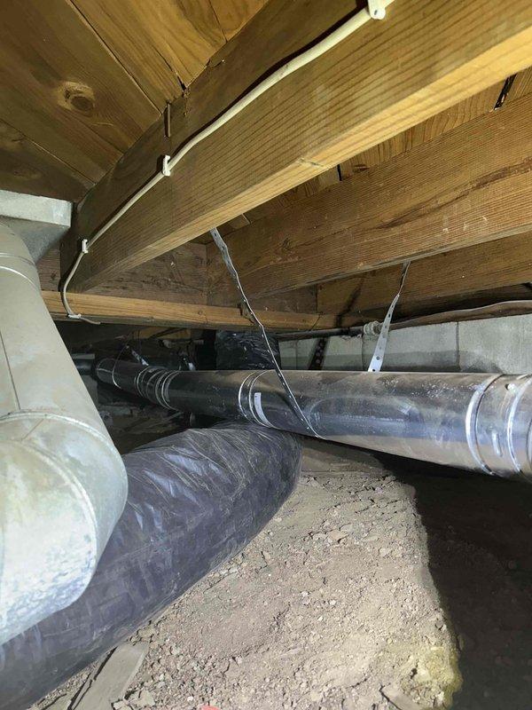 Successfully installed custom chimney liner for water heater and furnace vent in confined crawl space, requiring specialized technicians to navigate the restricted access area. Properly secured all ductwork connections with appropriate metal straps and bands to ensure code-compliant ventilation system operation.
