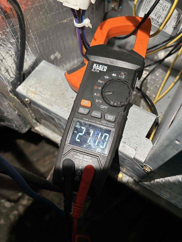 Performed second follow-up visit on heat pump/air handler system located in crawl space with washable filters. Conducted electrical diagnostics using clamp meter, measuring running load amperage (2.10A) and voltage (35.61V) to verify proper electrical operation of the equipment.
