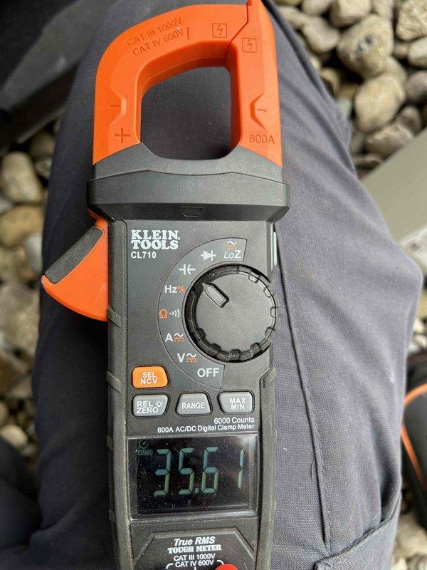 Performed second follow-up visit on heat pump/air handler system located in crawl space with washable filters. Conducted electrical diagnostics using clamp meter, measuring running load amperage (2.10A) and voltage (35.61V) to verify proper electrical operation of the equipment.