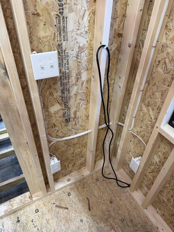 Completed installation of four 4" LED wafer lights in wooden ceiling, along with one GFCI outlet, two single-pole switches, and one weatherproof box with receptacle and cover. Ran SJ cord with male cord cap for power connection. Electrical rough-in work was performed in wood-paneled space with OSB sheathing prior to final finishing.