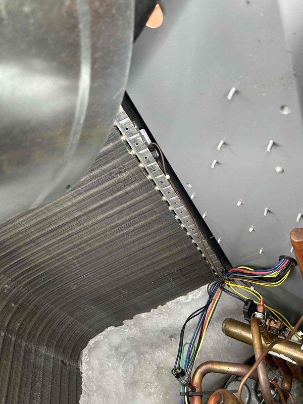 Responded to no heat call for guest house heat pump system. Upon inspection, discovered ice/frost accumulation on evaporator coil. Advised system shutdown to allow complete defrost before further diagnostics could be performed to identify underlying cause of freezing condition.