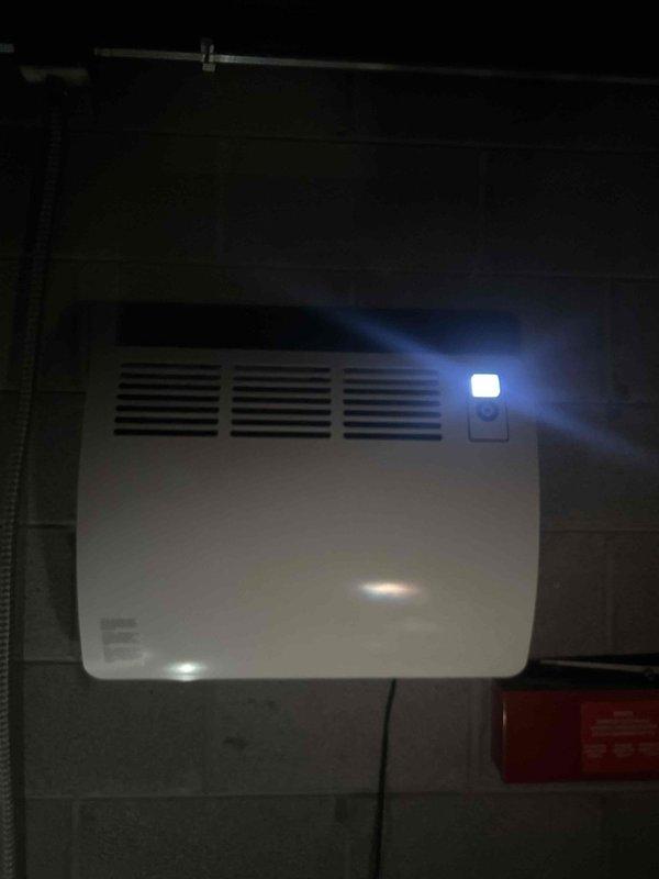 Successfully replaced outdated wall-mounted space heater with new CON 150-2 Premium wall-mounted electric convection heater on concrete block wall. Unit was properly mounted, connected to existing electrical supply via junction box, and tested for proper operation. Photographic documentation of completed installation was taken showing proper placement and functionality of new heating system.