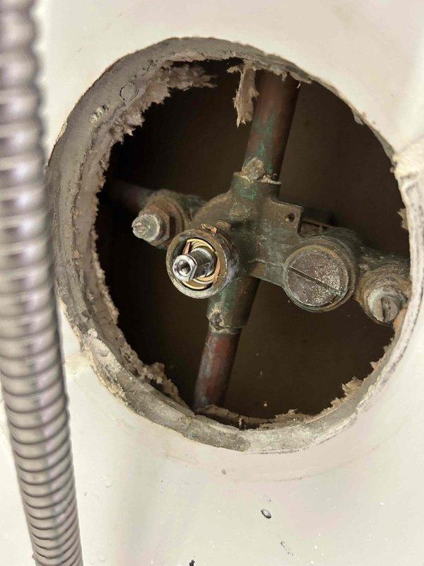 Diagnosed and repaired a leaking shower handle by accessing the valve assembly through the wall. Observed significant oxidation and corrosion on the copper supply pipes and valve components, which were contributing to the leak. Replaced damaged components, reassembled the fixture, and verified proper operation with no further leakage.