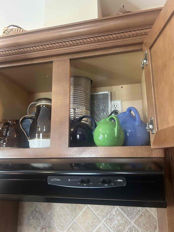 Completed electrical estimate for converting gas range to electric installation. Assessed existing electrical infrastructure, including cabinet-housed outlets and access panels, to determine requirements for proper 240V dedicated circuit installation and ventilation needs.