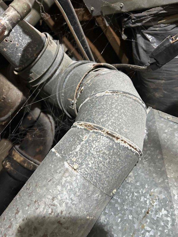 Responded to no-heat emergency call for a residence with 30-year-old thermostat and complete system failure. Upon inspection, found significant deterioration and dust accumulation in the ductwork with visible corrosion at connection points and joint seams. Replaced obsolete thermostat, cleaned critical components, and restored heating functionality to prevent potential freeze damage to the property.
