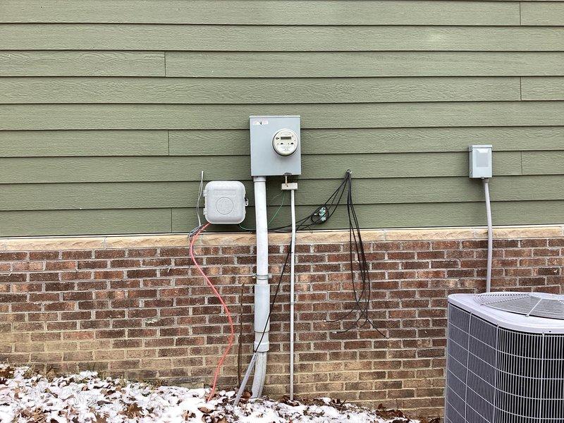 Conducted comprehensive evaluation of existing electrical panel and exterior utility connections for generator installation compatibility. Inspection revealed standard residential panel with adequate circuit capacity and well-organized wiring configuration. Documented exterior mounting location adjacent to existing meter and AC condenser, noting appropriate clearances and connection points for the proposed generator system.