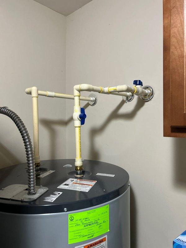 Conducted comprehensive assessment of multiple plumbing issues including Delta tub faucet requiring replacement and leak repair with potential tile work and access panel construction, kitchen faucet with intermittent drip requiring firm closure, and two standard toilets needing replacement with chair height models. Additionally evaluated 13-year-old water heater system with visible PVC piping configuration and multiple blue shut-off valves for replacement quote.
