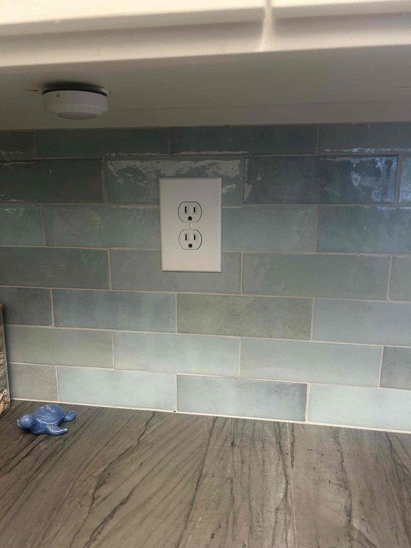 Diagnosed and repaired non-functioning kitchen outlet on tiled backsplash. Inspection revealed loose connection at receptacle terminal; removed outlet cover, tightened all terminal screws, and verified proper voltage. Tested outlet functionality with circuit tester confirming restoration of power to the previously non-working receptacle.