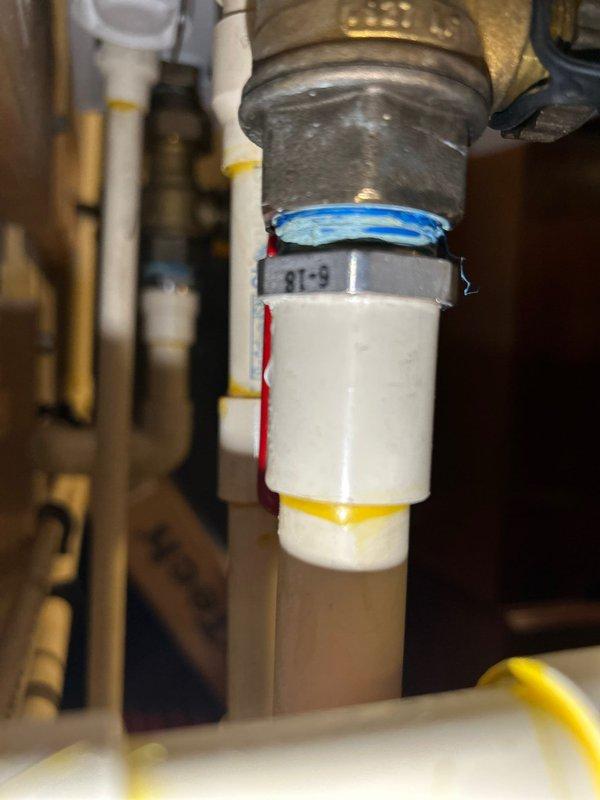 Responded to service call for a 5-year-old tankless water heater with pipe dripping at the bottom. Inspected PVC and brass plumbing connections, focusing on the area with visible moisture. Identified and repaired leak at PVC-to-brass connection point, verifying all fittings and shutoff valves were properly secured and functioning correctly.