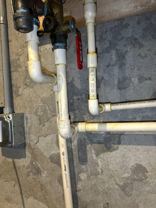 Responded to service call for a 5-year-old tankless water heater with pipe dripping at the bottom. Inspected PVC and brass plumbing connections, focusing on the area with visible moisture. Identified and repaired leak at PVC-to-brass connection point, verifying all fittings and shutoff valves were properly secured and functioning correctly.