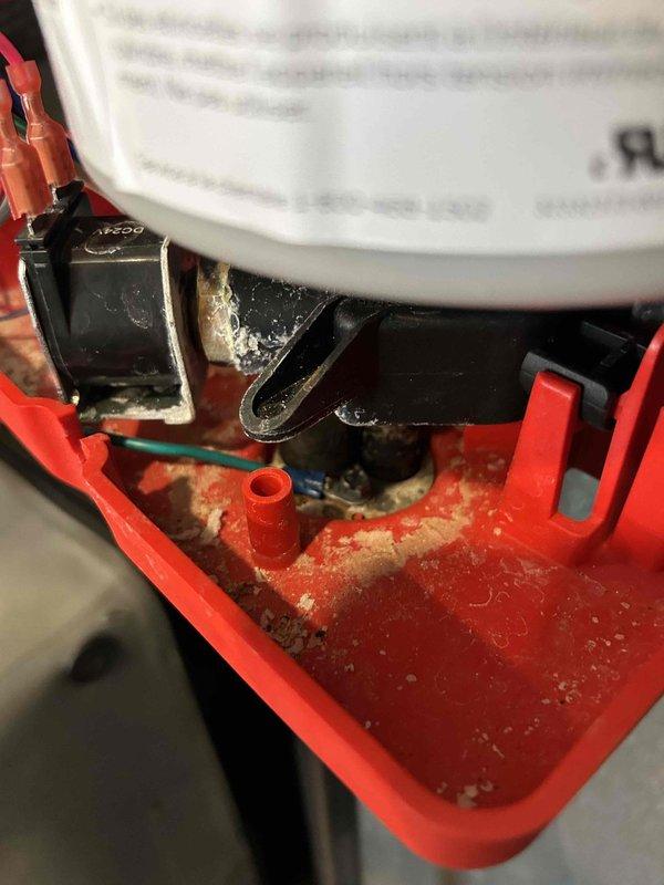 Responded to customer-reported whole-house humidifier malfunction. Upon inspection, discovered significant mineral buildup and corrosion within the red housing assembly, particularly affecting the electrical connections and valve marked "N290". Determined the issue was due to mineral accumulation rather than improper installation, and performed necessary cleaning and component replacement to restore proper humidifier operation.