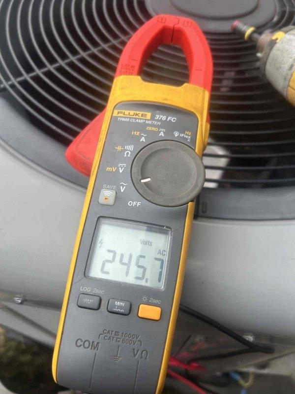 Performed routine maintenance on residential AC system with 16x25x1 filter located in garage. Inspected outdoor condenser unit, noting dust/debris accumulation on coil fins requiring cleaning. Conducted electrical diagnostic testing with Fluke 376 FC meter, confirming proper voltage at 245.7 VAC.