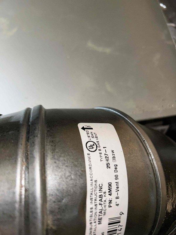Completed warranty inspection of HVAC installation, focusing on furnace flue components. Documented installation compliance via photographic evidence of component labeling (PN: 4-M90) and crawl space ductwork with proper insulation. Additional flue inspection photos pending as requested.