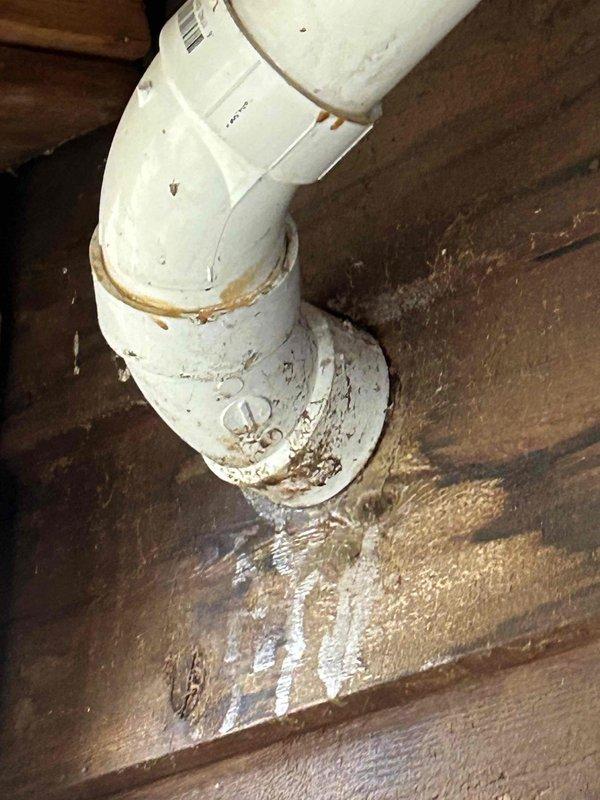 Inspected HVAC condensate line in garage exhibiting significant backup issues. Identified deteriorated PVC piping with visible rust staining and water damage to surrounding wooden structures. Repaired disconnected section of condensate drainage system and addressed pooling water issue to restore proper drainage functionality.