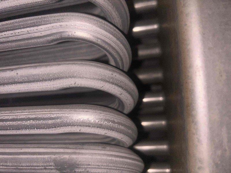 Responded to non-urgent service call for unit with suspected heat exchanger and blower issues. Upon inspection, discovered significant frost/condensation buildup on evaporator coil and evidence of corrosion or algae growth on metal surfaces. Examination of heat exchanger confirmed safety concerns with visible deterioration of metal coils and compromised structural integrity.