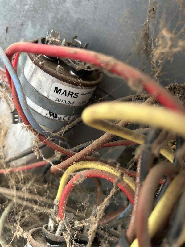 Performed comprehensive tune-up service on dual HVAC systems (20-year and 10-year units). Inspection revealed significant dust/debris accumulation and cobweb buildup around the MARS 30+3.0μF capacitor and electrical connections. Conducted electrical testing with Fieldpiece SC440 meter, verifying proper voltage readings of 600.2V across components to ensure system functionality.