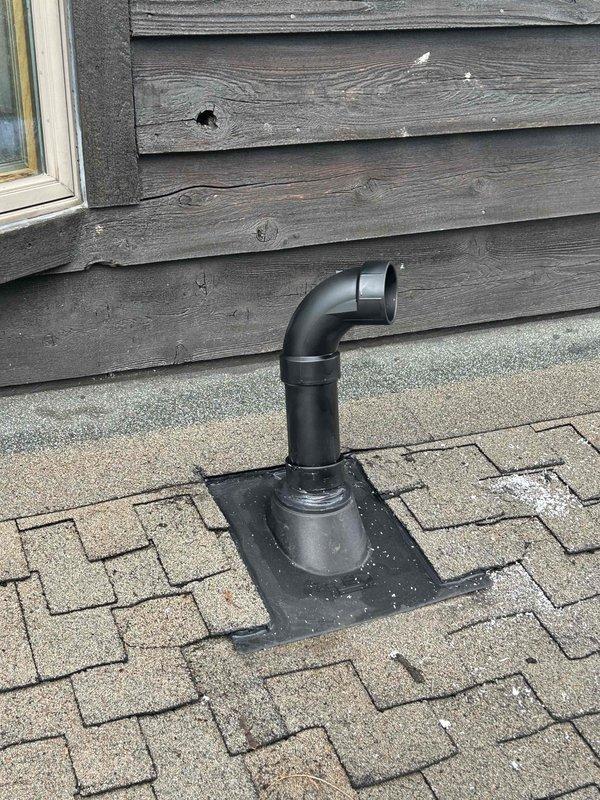 Completed roof vent repair associated with Trane HVAC system. Installed new black vent pipe with elbow configuration on proper flashing base, ensuring proper sealing to roof surface. Verified interior PVC drainage connections in utility area were secure and properly aligned with the exterior ventilation components.