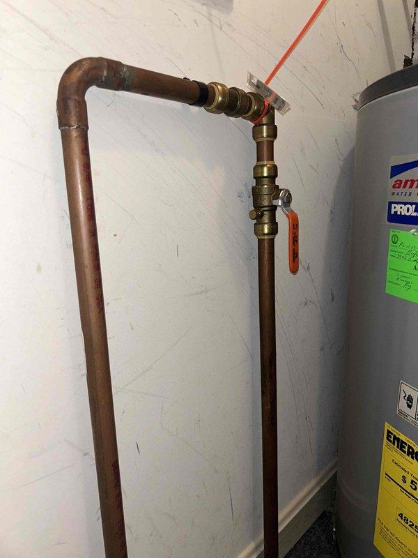Conducted inspection of 47-gallon American electric water heater located in utility closet between kitchen and dining room. Evaluated existing copper plumbing connections, including L-shaped pipe configuration with brass fittings and valve mechanism. Documented unit specifications (Model E62-50L-045OV) and current installation condition for estimate purposes.